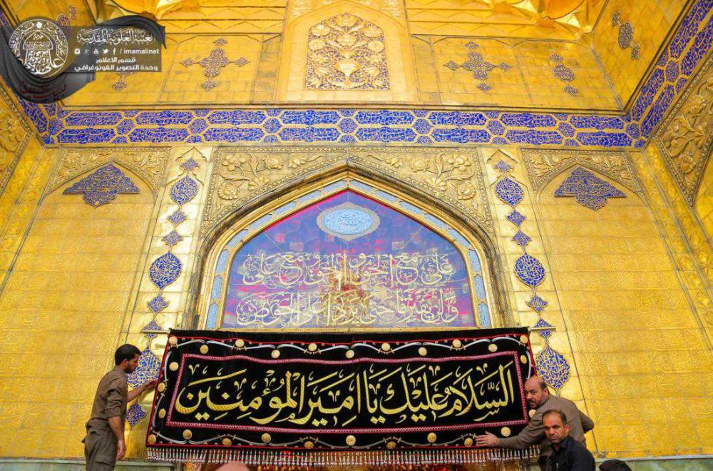 المدخل الرئيسي للمرقد العلوي الطاهر يتشح بكتيبة قماشية مطرزة بماء الذهب ومزينة بالأحجار الكريمة تبرع بها زائرون من باكستان