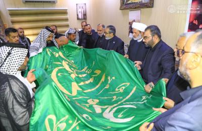 وفد لجنة إدارة العتبة العلوية المقدسة يسلم راية أمير المؤمنين (ع) لخادم الإمام الحسين (ع) الفاقد لأربعة من أفراد عائلته في محافظة البصرة