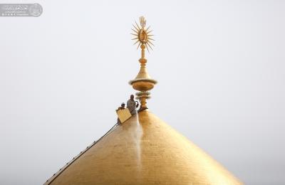 أيادي خدم أمير المؤمنين (عليه السلام) تتشرف بملامسة القبة الطاهرة في عيد الغدير الأغر